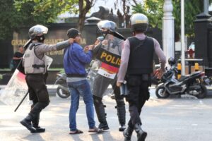 polisi mencengkram kerah jaket demonstran [BP2M/Lalu]