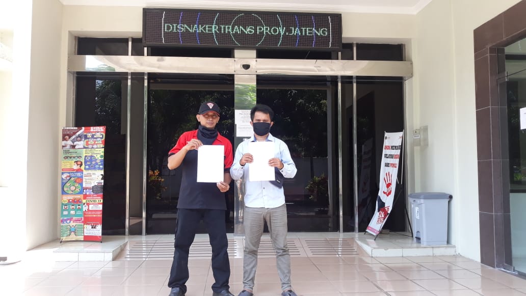 keterangan foto: Zainuri, dari Federasi Serikat Pekerja Indonesia Perjuangan (FSPIP) dan Herdin (Berbaju putih) membawa surat protes di depan kantor DISNAKERTRANS Provinsi Jawa Tengah [Doc. Alvin, LBH Semarang]