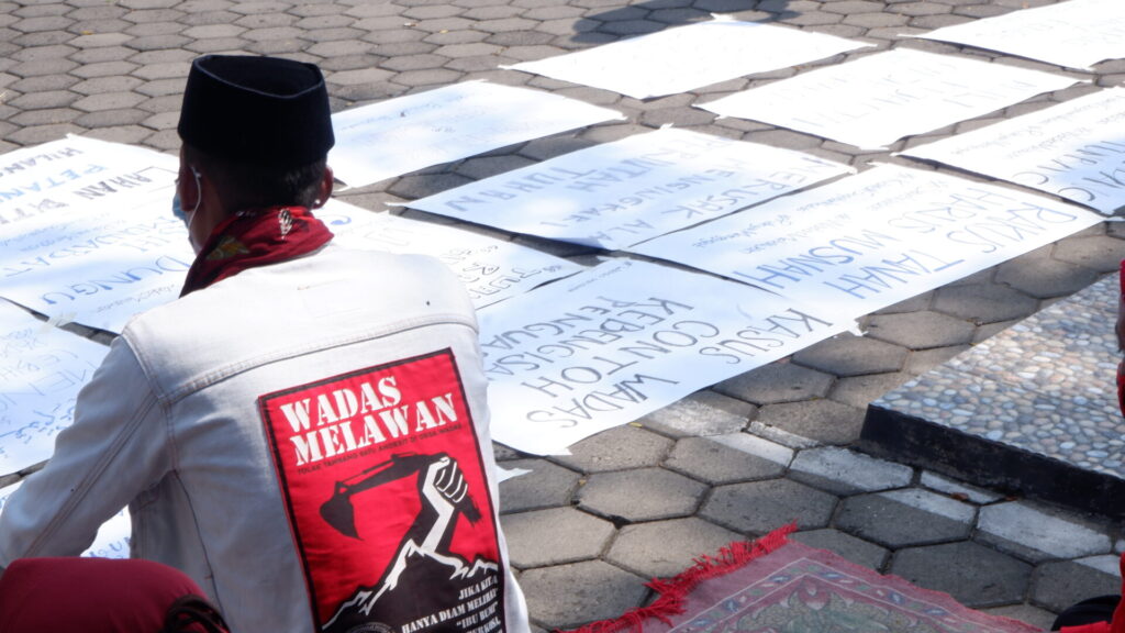 Warga Wadas menunggu di halaman PTUN Semarang dan membawa berbagai atribut poster [BP2M/Adam].