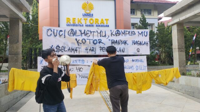 Terlihat beberapa jas almamater dijemur berjajar di depan Gedung Rektorat Unnes dibarengi dengan penyampaian orasi oleh korlap aksi pada Jumat (2/4). Terlihat beberapa jas almamater dijemur berjajar di depan Gedung Rektorat Unnes dibarengi dengan penyampaian orasi oleh korlap aksi pada Jumat (2/4).