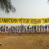 Masyarakat nelayan Roban Timur membentangkan spanduk dan poster kampanye dalam tradisi sedekah laut. [Dok. WALHI Jateng]