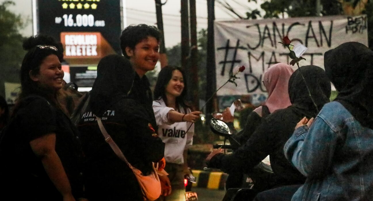 Massa aksi membagikan bunga mawar kepada pengguna jalan di Simpang Tujuh, Unnes, Jumat (4/10). [BP2M/Rifky]