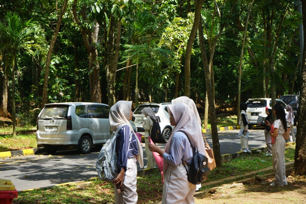 Telihat dua orang sedang berdiskusi di halaman dekat gedung diselenggarakannya UTBK. (Fabu, 23 April 2025) [Puji/BP2M]