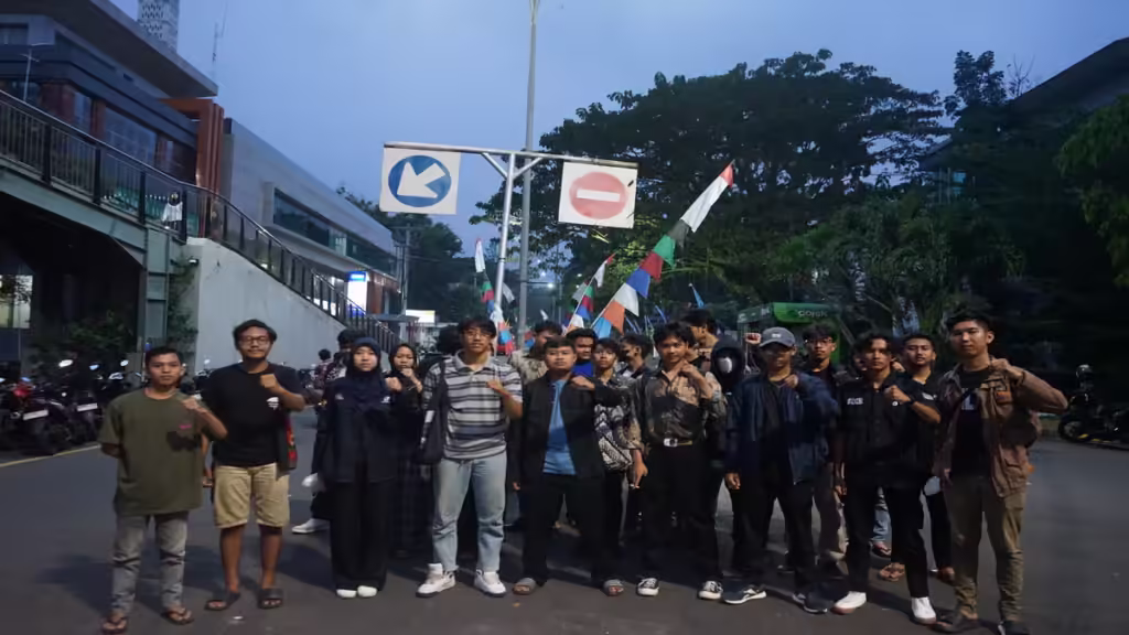 Para mahasiswa tengah mengepalkan tangan dalam aksi solidaritas terhadap kawan mereka yang sedang ditahan. (Kamis, 22/05/2025) [Lidwina/BP2M]