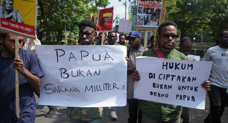 Dua orang bersama dengan massa aksi yang lain tengah membentangkan karton bertuliskan “Papua bukan sarang militer” dan “Hukum diciptakan bukan untuk Orang Papua”. (Rabu, 28/05/2025) [Lidwina/BP2M]