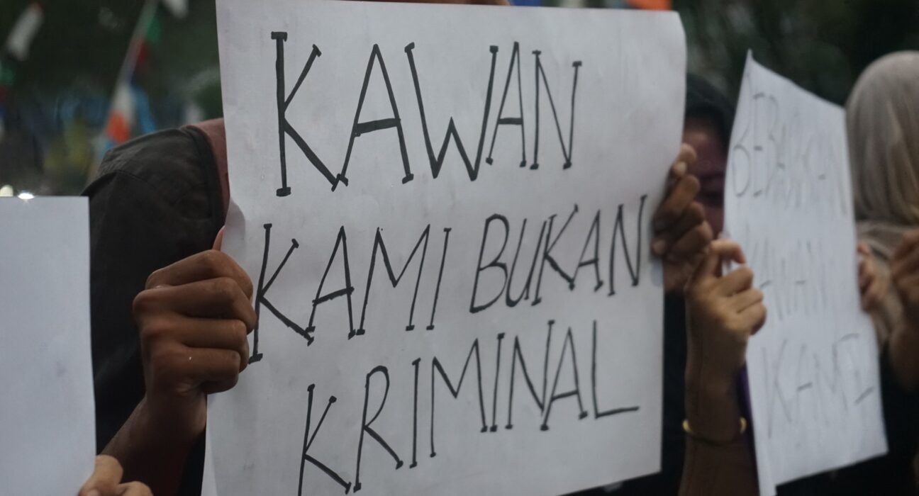 Seorang mahasiswa membentangkan kertas seruan yang bertuliskan “Kawan Kami Bukan Kriminal”. (Rabu, 21/05/25) [Ann/Magang BP2M]