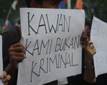 Seorang mahasiswa membentangkan kertas seruan yang bertuliskan “Kawan Kami Bukan Kriminal”. (Rabu, 21/05/25) [Ann/Magang BP2M]