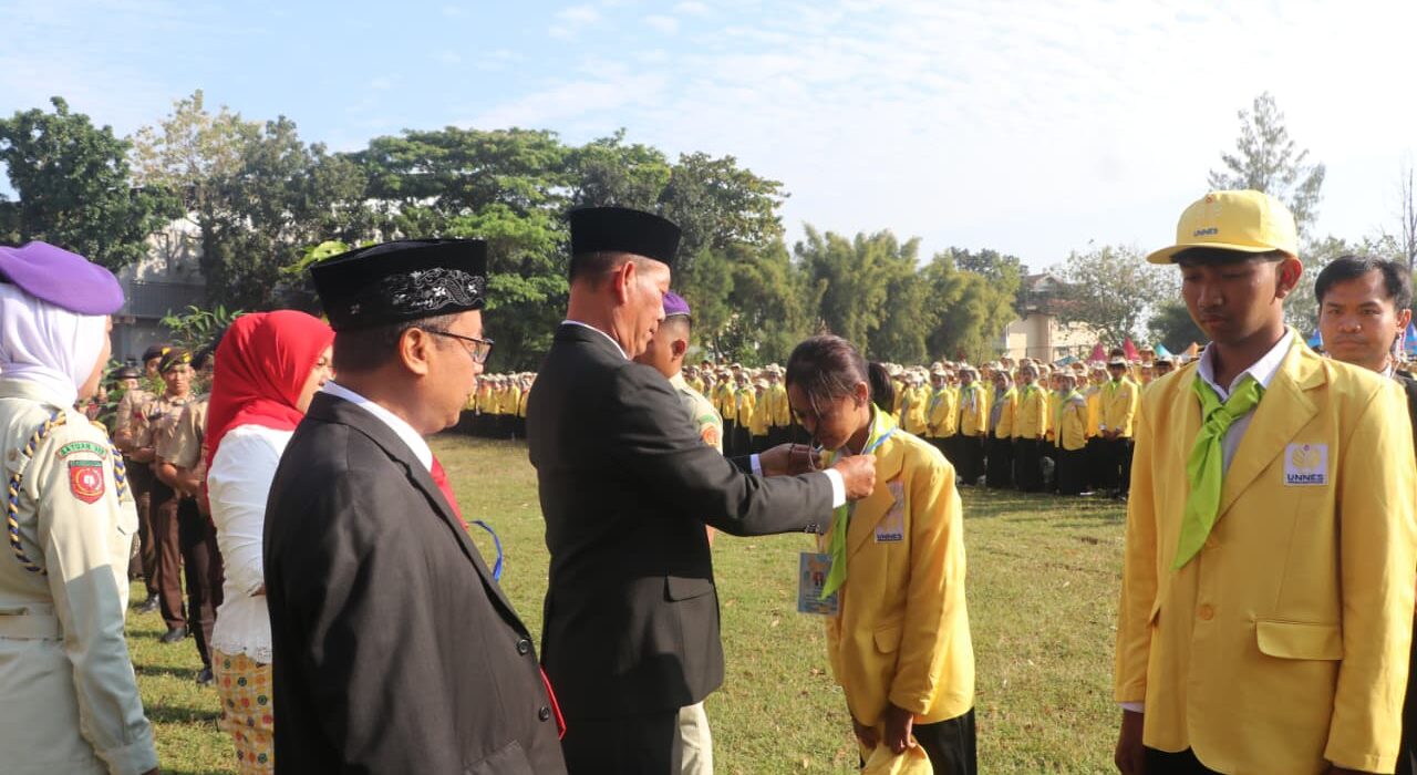 Rektor Unnes memberikan ID card sebagai simbol penyambutan mahasiswa baru di lapangan Prof. Dumadi, Minggu (17/8) [Sultan/BP2M]