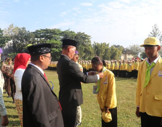 Rektor Unnes memberikan ID card sebagai simbol penyambutan mahasiswa baru di lapangan Prof. Dumadi, Minggu (17/8) [Sultan/BP2M]