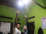 Dua orang sedang menunjuk lampu yang aliran listrik salah satu lampunya berasal dari PLTMh (Sabtu, 25/10/2025) [BP2M]