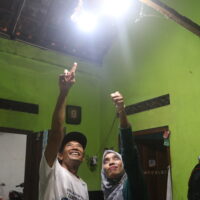 Dua orang sedang menunjuk lampu yang aliran listrik salah satu lampunya berasal dari PLTMh (Sabtu, 25/10/2025) [BP2M]