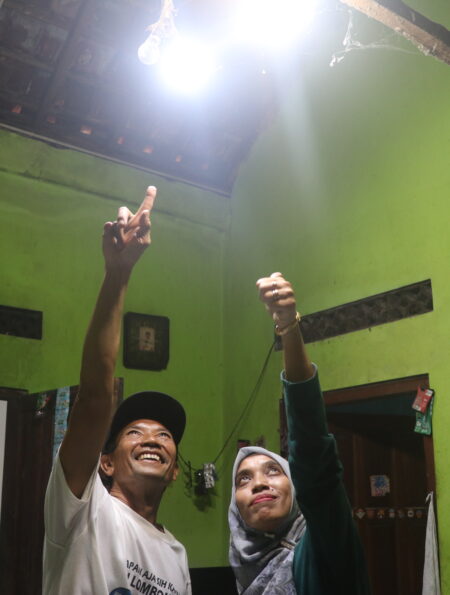 Dua orang sedang menunjuk lampu yang aliran listrik salah satu lampunya berasal dari PLTMh (Sabtu, 25/10/2025) [BP2M]