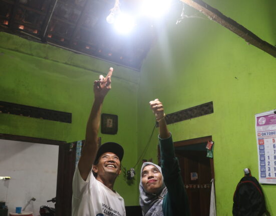 Dua orang sedang menunjuk lampu yang aliran listrik salah satu lampunya berasal dari PLTMh (Sabtu, 25/10/2025) [BP2M]