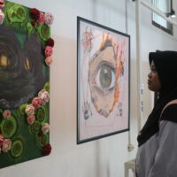 Seorang pengunjung tengah mengamati lukisan “Liminal” oleh Puii yang mengisahkan penyesalan seseorang di masa lalu, Minggu (30/12/2025) [Hanna/BP2M]