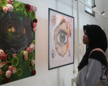 Seorang pengunjung tengah mengamati lukisan “Liminal” oleh Puii yang mengisahkan penyesalan seseorang di masa lalu, Minggu (30/12/2025) [Hanna/BP2M]