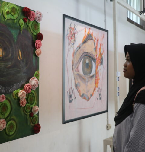 Seorang pengunjung tengah mengamati lukisan “Liminal” oleh Puii yang mengisahkan penyesalan seseorang di masa lalu, Minggu (30/12/2025) [Hanna/BP2M]