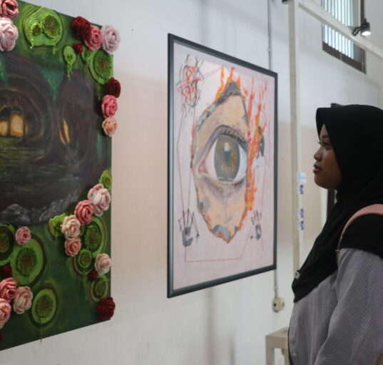 Seorang pengunjung tengah mengamati lukisan “Liminal” oleh Puii yang mengisahkan penyesalan seseorang di masa lalu, Minggu (30/12/2025) [Hanna/BP2M]