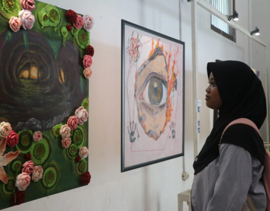 Seorang pengunjung tengah mengamati lukisan “Liminal” oleh Puii yang mengisahkan penyesalan seseorang di masa lalu, Minggu (30/12/2025) [Hanna/BP2M]