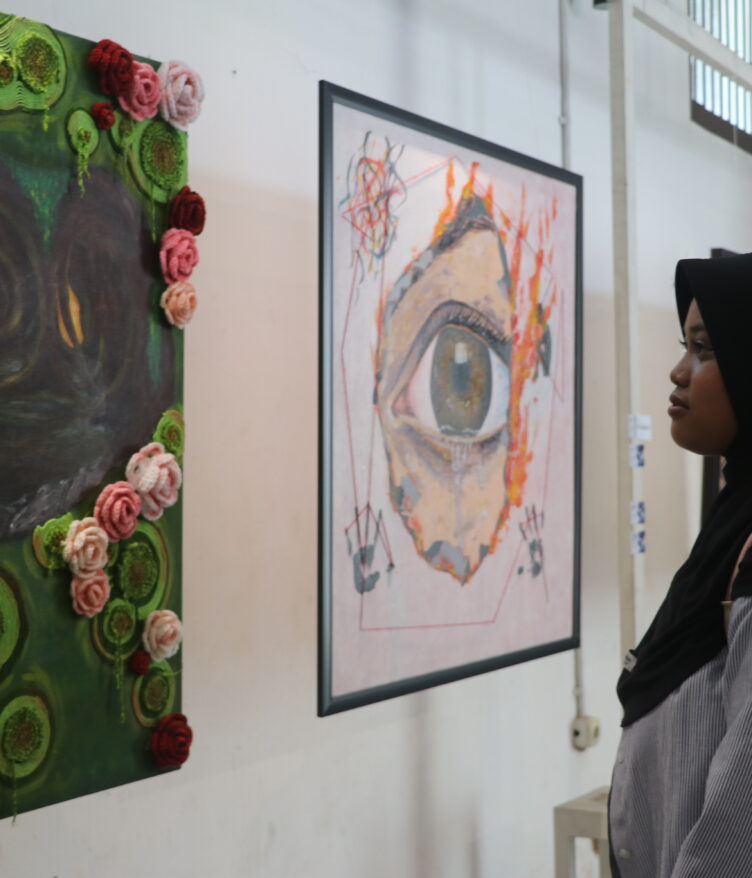 Seorang pengunjung tengah mengamati lukisan “Liminal” oleh Puii yang mengisahkan penyesalan seseorang di masa lalu, Minggu (30/12/2025) [Hanna/BP2M]