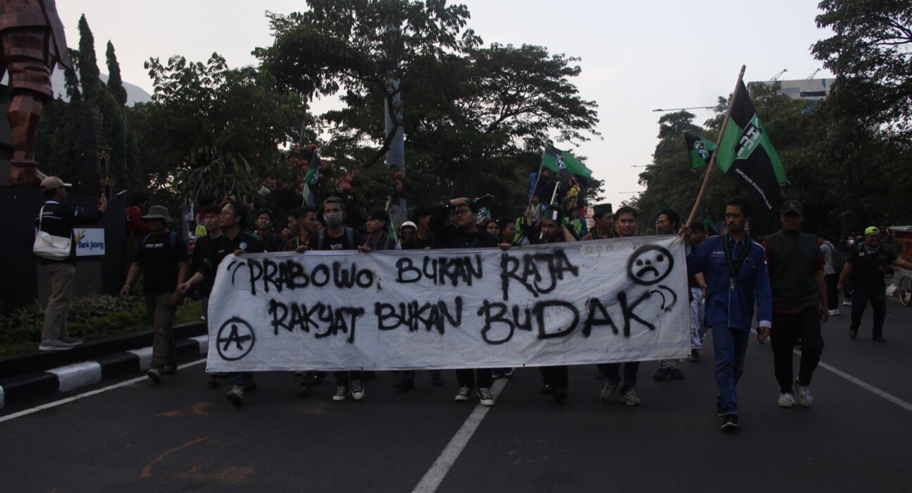 Peserta demo berjalan membawa banner yang berisi kritik mereka terhadap Pemerintah, Senin, (15/06/2026) [Rayhan/Magang BP2M]