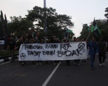 Peserta demo berjalan membawa banner yang berisi kritik mereka terhadap Pemerintah, Senin, (15/06/2026) [Rayhan/Magang BP2M]