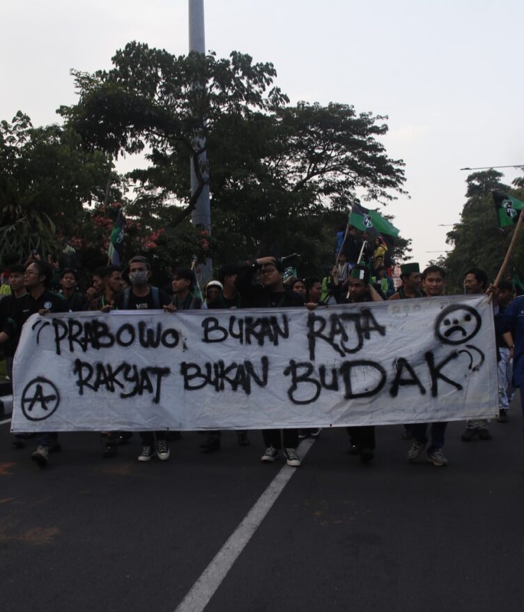 Peserta demo berjalan membawa banner yang berisi kritik mereka terhadap Pemerintah, Senin, (15/06/2026) [Rayhan/Magang BP2M]